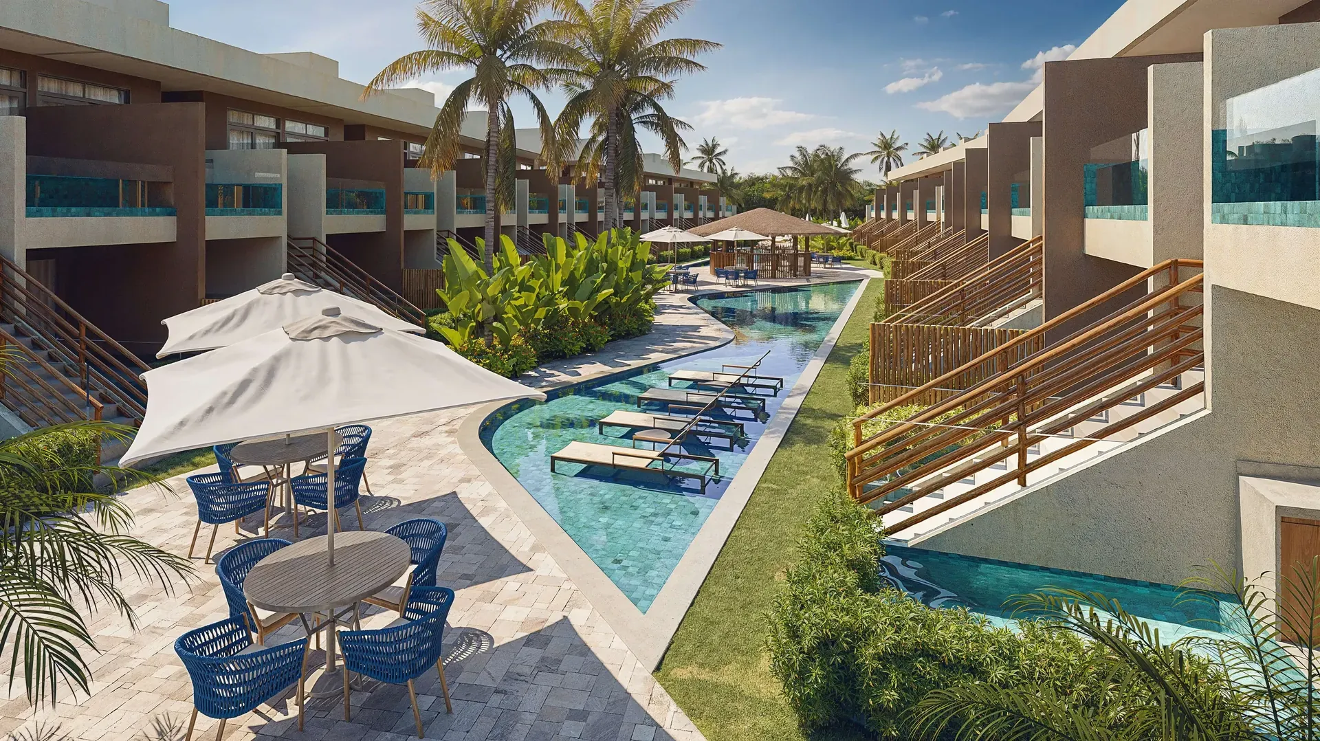Deck com mesas, guarda-sóis e piscina em curva